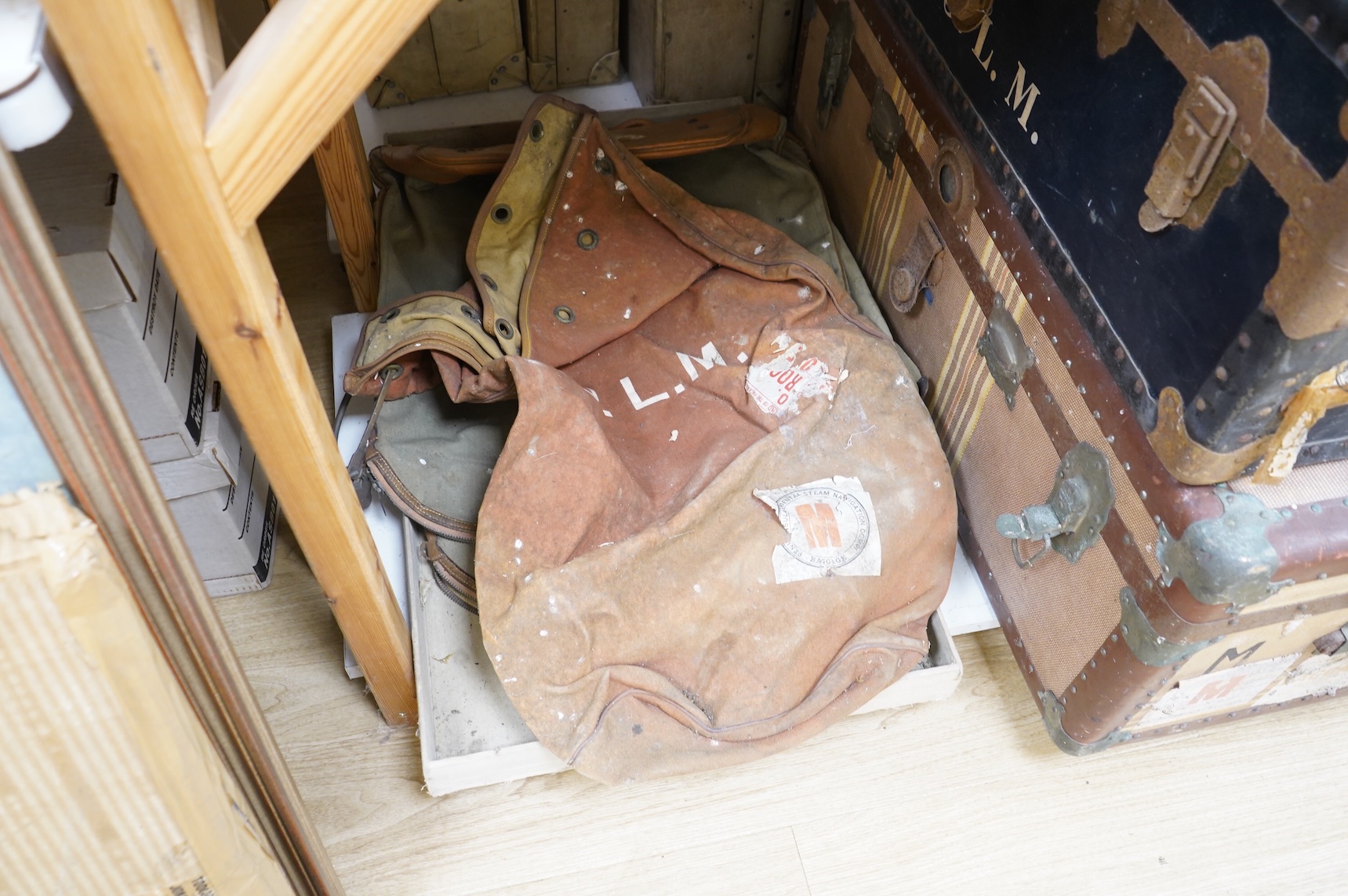 A collection of vintage luggage comprising four early 20th century bound travelling trunks and three kit bags